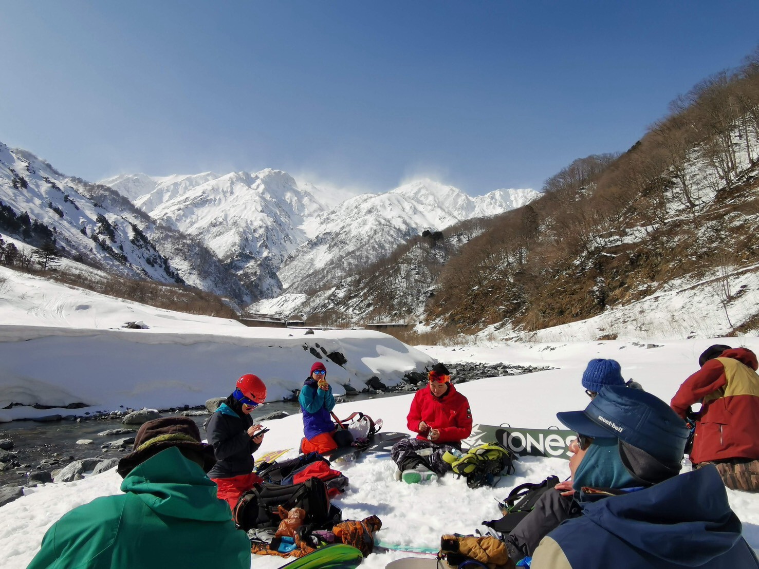 Group relaxing on snow-covered riverbank